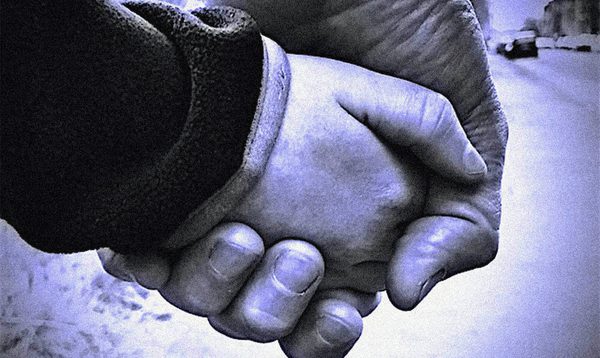 black and white image of an adult and child's held hands