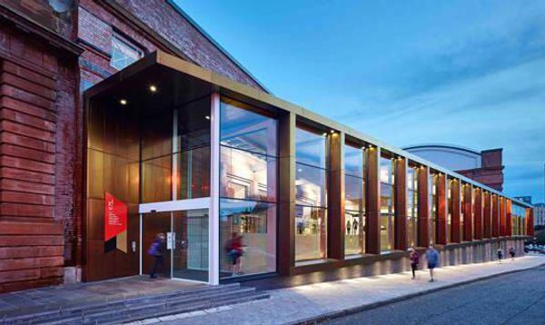External photo of Kelvin Hall in Glasgow, a modern building with large glass windows, connected to an older sandstone building behind.
