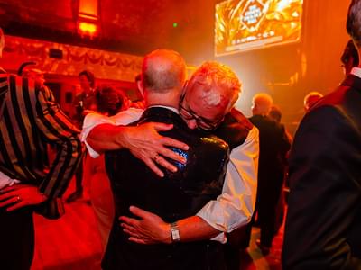 Two older men embracing each other as they dance.