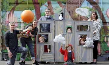 A group of adults and children holding props on a set