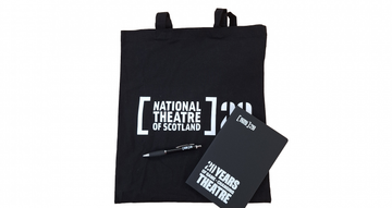 NTS 20th tote bag, pen and notebook sit on a white background