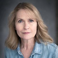 Hilary MacLean looks at the camera. She is wearing a denim shirt.