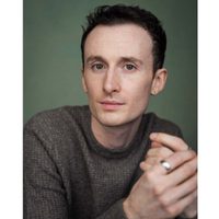 Jay Newton watched the camera intently. He wears a grey jumper.