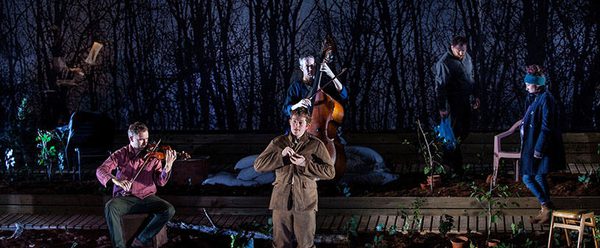 Five performers in an allotment with two playing string instruments