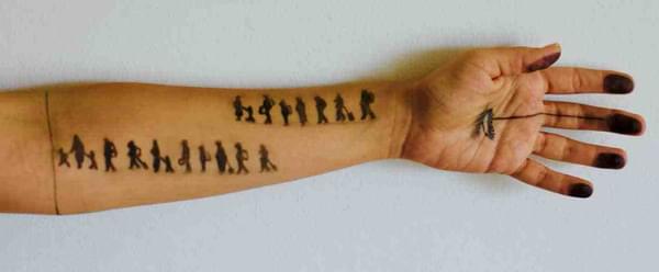 An arm with people drawn on it.