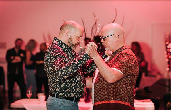 Two men holding hands and dancing together