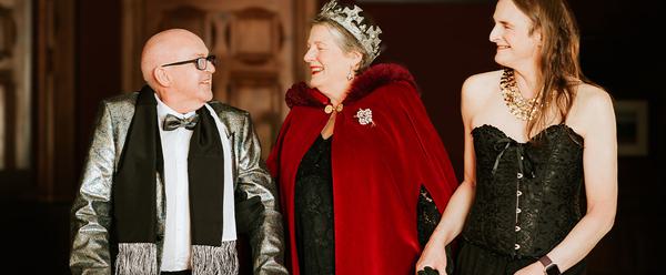 A photograph of three people dressed up for The Coming Back Out Ball.