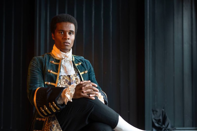 The lead actor sits in period dress