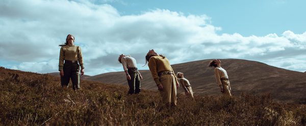 Five figures leaning backwards on a mountain