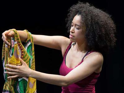 A young woman holds a yellow dress on her arm