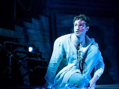 A young man in white pajamas and a red birth mark on his face looks afraid.