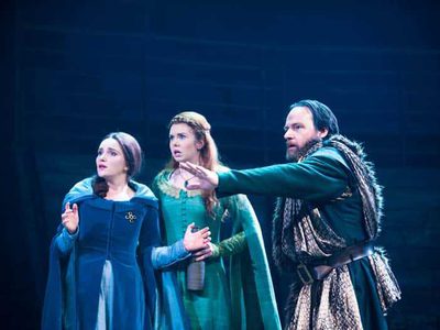 A man stands next to two women - his hand stretched outwardly in defense.