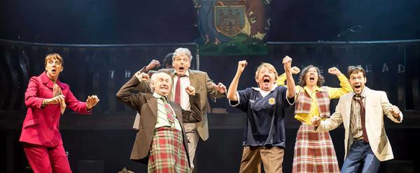 A group of people in Scottish-themed attire cheer