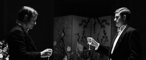 Two men in fancy suits drink together