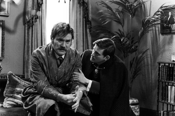 A distressed actor with a handlebar moustache is comforted by another