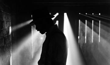 A man in a hat is barely visible, cast in silhouette