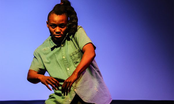 A man performs a movement piece on stage