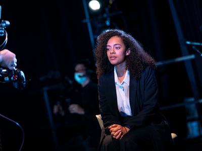 A woman in a shirt and blazer in front of the camera