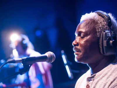 A man wearing headphones sits in front of a microphone