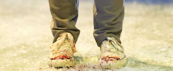 A pair of trainers in the snow speckled with blood.