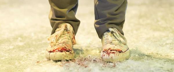 A pair of trainers in the snow speckled with blood