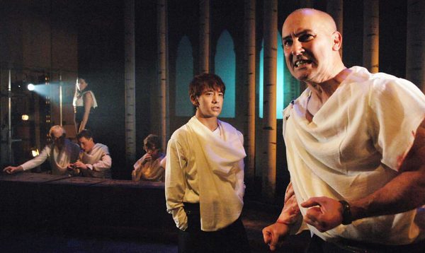 A man clenches his fist as others look towards him.