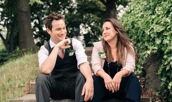 A young man and woman looking at each other, wearing formal clothing