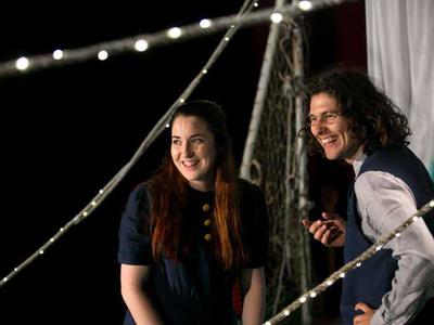 a man and a woman laughing with fairy lights in the background and foreground