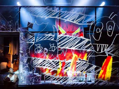 Children's drawings are displayed over the front of the stage