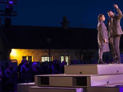 A man and a woman stand facing one another