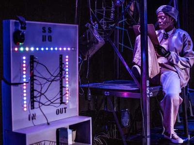 Augusta, one of the slumber sisters, is sitting on the look out post reading notes from a clipboard.