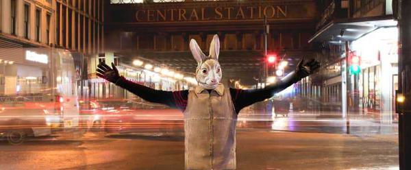 A human size bunny stands in front of Glasgow Central Station at night time