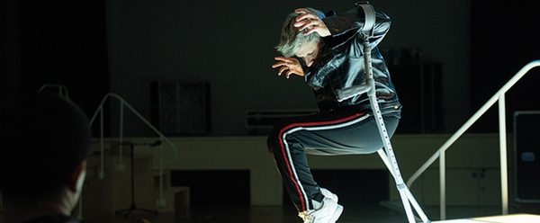 Person using crutches is positioned in a sitting position with hands at either side of their head
