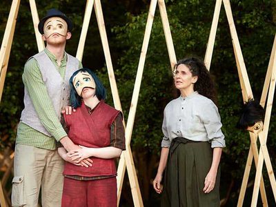 Three people on stage, two are wearing masks