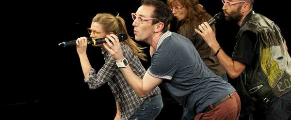 Performers in rehearsal, singing into microphones