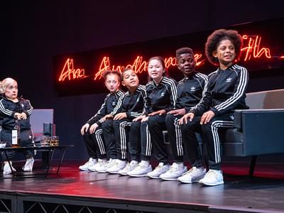 Kiruna and kids on the TV chat show set. They are all wearing matching tracksuits