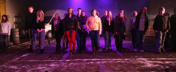 A group of performers under pink lights