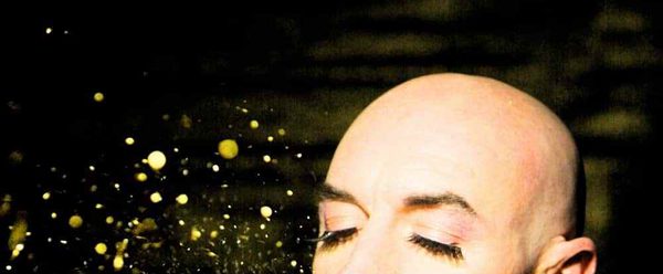 Performer blowing gold glitter from their palm