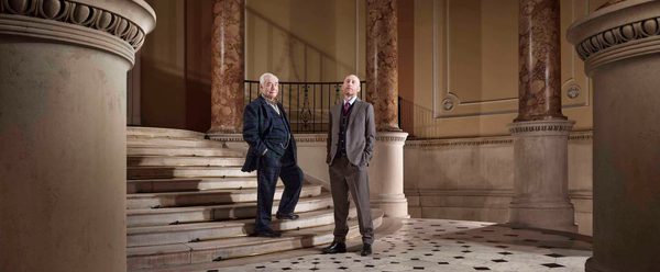 actors Brian Cox and Sandy Grierson stand on a marble staircase