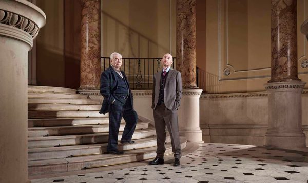 actors Brian Cox and Sandy Grierson stand on a marble staircase