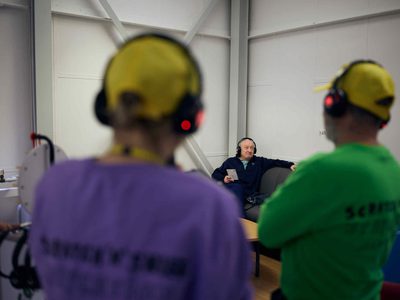 Trolleydarity facilitators watch a hospital visitor as he experiences a Scratch n Sniff Vacation