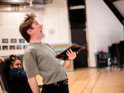 An actor hold a script a screams comedically into the void.